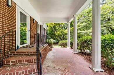 Porch featuring view of wooded area