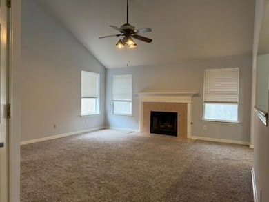 Unfurnished living room featuring baseboards, a t