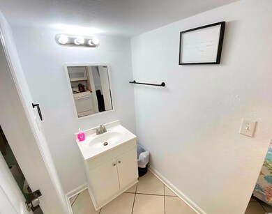Bathroom featuring vanity, tile patterned floors, and baseboards