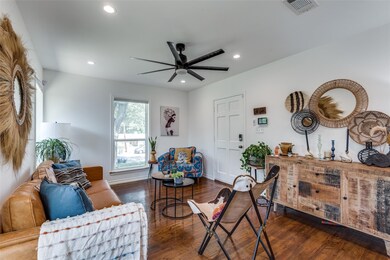 Living room featuring ceiling fan and dark hardwoo