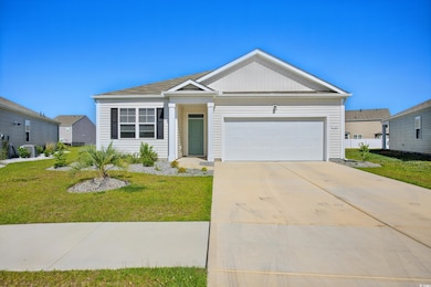 View of front of house featuring a front yard, an attached garage, and concrete driveway