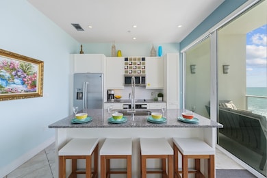 Modern kitchen featuring stainless steel appliances, sleek cabinetry, granite countertops.