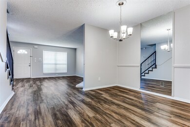 Entryway featuring an inviting chandelier, dark ha