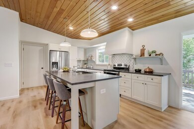 Fantastic kitchen equipped with crisp-white soft close cabinetry, black granite countertops, brand-new stainless steel appliances, and large center island with breakfast bar seating.