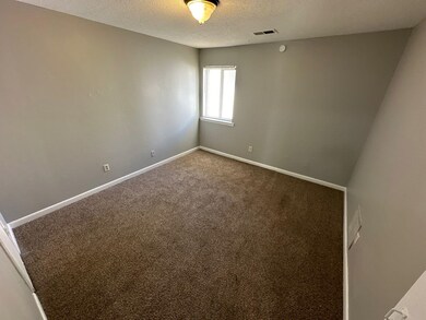 Unfurnished room with carpet and a textured ceilin