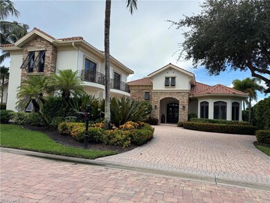 Mediterranean / spanish house with stucco siding, stone siding, a tile roof, and decorative driveway