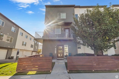 Modern home featuring a balcony and a fenced front yard
