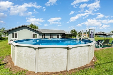 Outdoor pool featuring a patio and a lawn