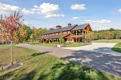 View of property's community featuring a lawn, driveway, a porch, and a forest view