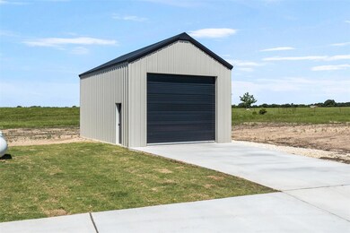 Detached garage with concrete driveway and a rura