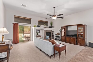 Living area with a ceiling fan and a fireplace