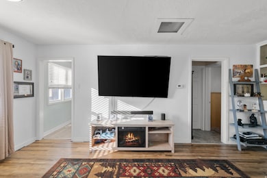 Living room with a textured ceiling and wood finished floors