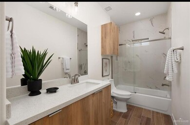 Kitchen with electric panel, modern cabinets, a sink, light countertops, and appliances with stainless steel finishes