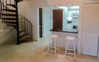 View from Living Room towards Kitchen, Spiraling staircase, and 1/2 bathroom.