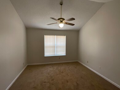 Carpeted empty room featuring vaulted ceiling and 