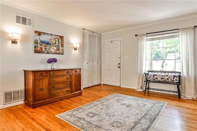 Bright and welcoming entryway featuring gleaming hardwood floors