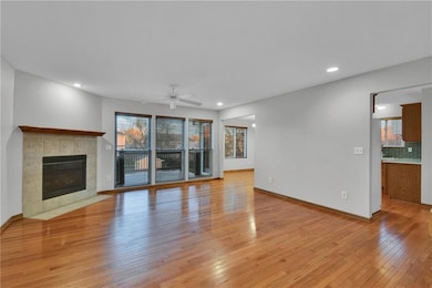 Unfurnished living room with light wood-style flooring, a tile fireplace, recessed lighting, and ceiling fan