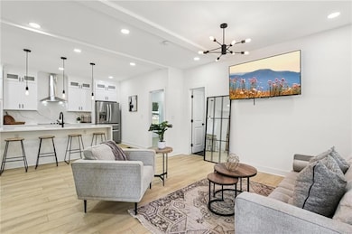 Living area featuring a chandelier, recessed lighting, and light wood-style floors