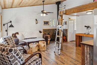 Living area featuring a ceiling fan, wood ceiling,