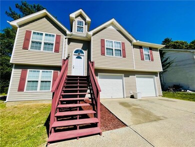 Bi-level home featuring a garage, driveway, and a front yard