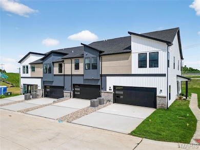 View of front of property featuring an attached garage, a shingled roof, driveway, and brick siding