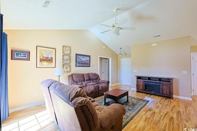 Living area featuring light wood-type flooring, a ceiling fan, and high vaulted ceiling