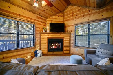 Living room featuring lofted ceiling, wooden ceiling, ceiling fan, and wood walls