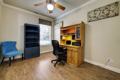 Located off the front entry, this dedicated home office provides the perfect space for remote work or study and boasts crown molding, laminate flooring, and a window with front-yard views.