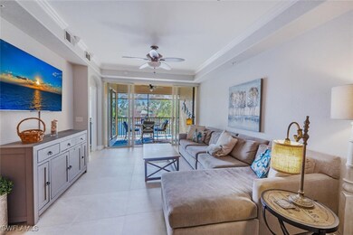 Living room with crown molding, a ceiling fan, light tile patterned floors, a raised ceiling, and a sunroom