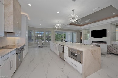 with Appliances with Stainless Steel Finishes, Crown Molding, Recessed Lighting,  Fireplace, and Light Marble Style Flooring