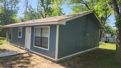 View of side of home with roof with shingles
