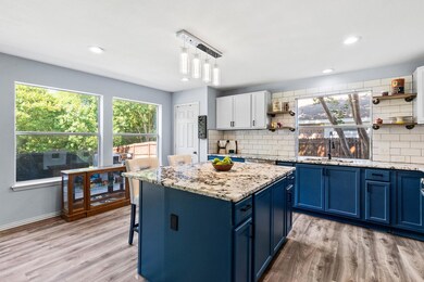 Kitchen island has cabinets and breakfast bar.