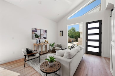 Living room featuring a barn door, high vaulted c