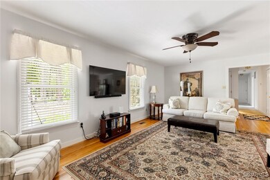 Living area featuring a ceiling fan, light wood-st