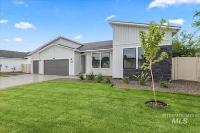 View of front facade with driveway, an attached garage, board and batten siding, and stone siding