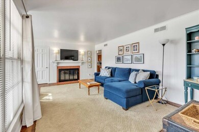 Living area featuring a brick fireplace and baseboards