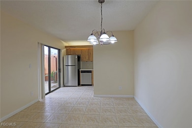 Unfurnished dining area with light tile patterned floors, a chandelier, and a textured ceiling