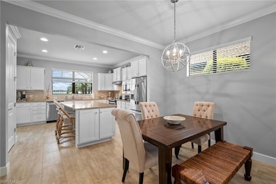 Dining space featuring a chandelier, ornamental molding, and recessed lighting