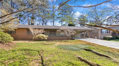 Single story home featuring brick siding, a carpor