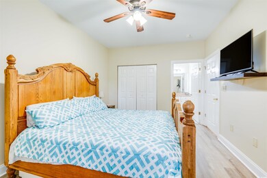 Bedroom featuring ensuite bath, ceiling fan, a clo