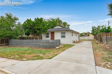 Bungalow-style house featuring driveway, stucco siding, a fenced front yard, and roof with shingles