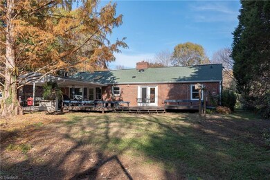 Back of the home shows the 2 car carport and multi-level deck with build=in bench seating.