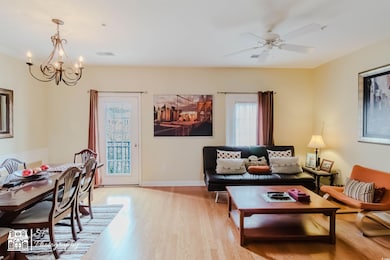 Living area featuring visible vents, light wood-st