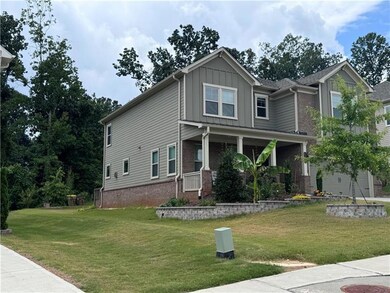 View of front of property featuring board and batten siding, a porch, a front lawn, and brick siding