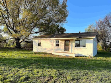 Rear view of property with a yard and brick siding