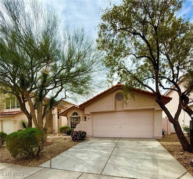 View of front of home with a tile roof, driveway,