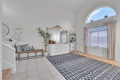 Bedroom with high vaulted ceiling and light tile patterned floors