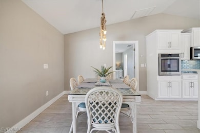 Dining area featuring lofted ceiling, light wood-s
