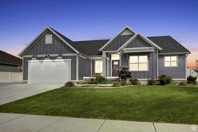 View of front facade featuring board and batten siding, concrete driveway, a yard, and a shingled roof