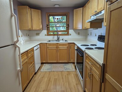 Kitchen with backsplash, sink, white appliances, a